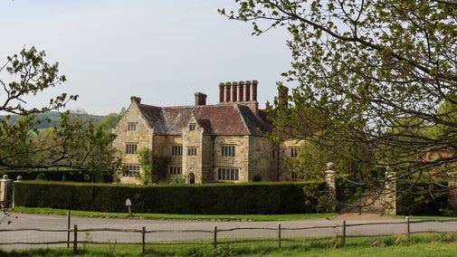 Grass field in the foreground with Bateman's house in the background.